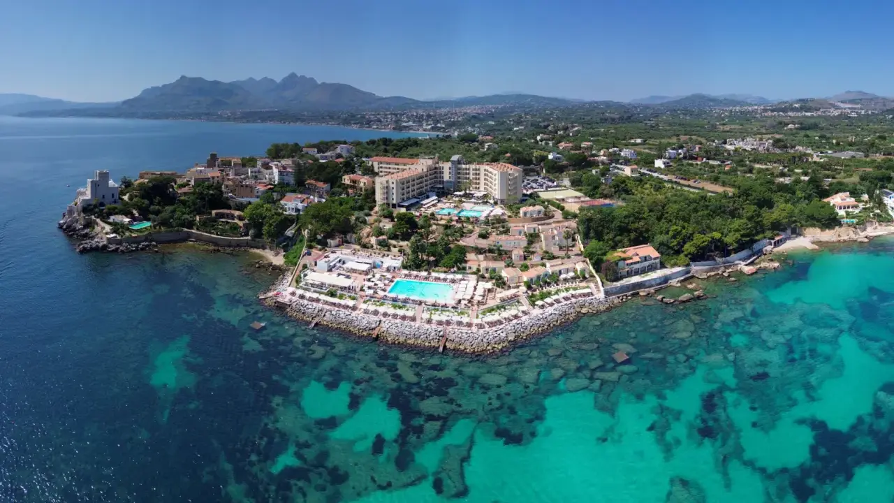 Resort costiero con piscine e mare cristallino, un luogo dove le parole siciliane risuonano tra le ville e la natura.