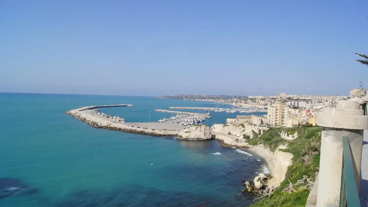Vista panoramica del porto di Sciacca, con barche ormeggiate e la città sullo sfondo. Ideale per scoprire cosa vedere in un giorno.