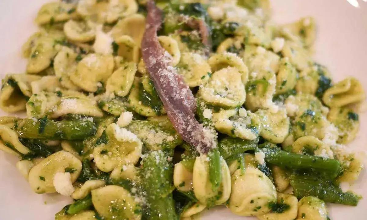 Orecchiette con cime di rapa, uno dei piatti tipici pugliesi primi, condite con acciughe e formaggio grattugiato.