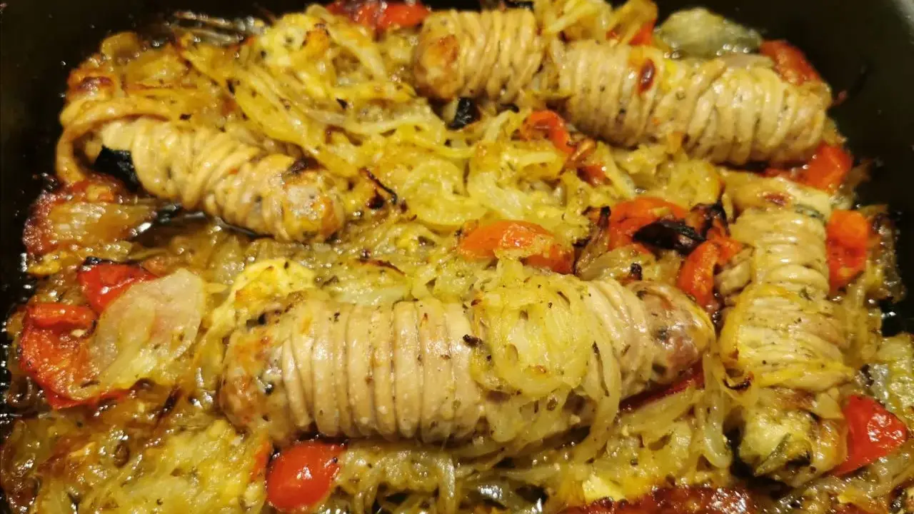 Stigghiole palermitane, un piatto saporito con interiora di agnello arrotolate e cotte al forno con cipolle e pomodorini.