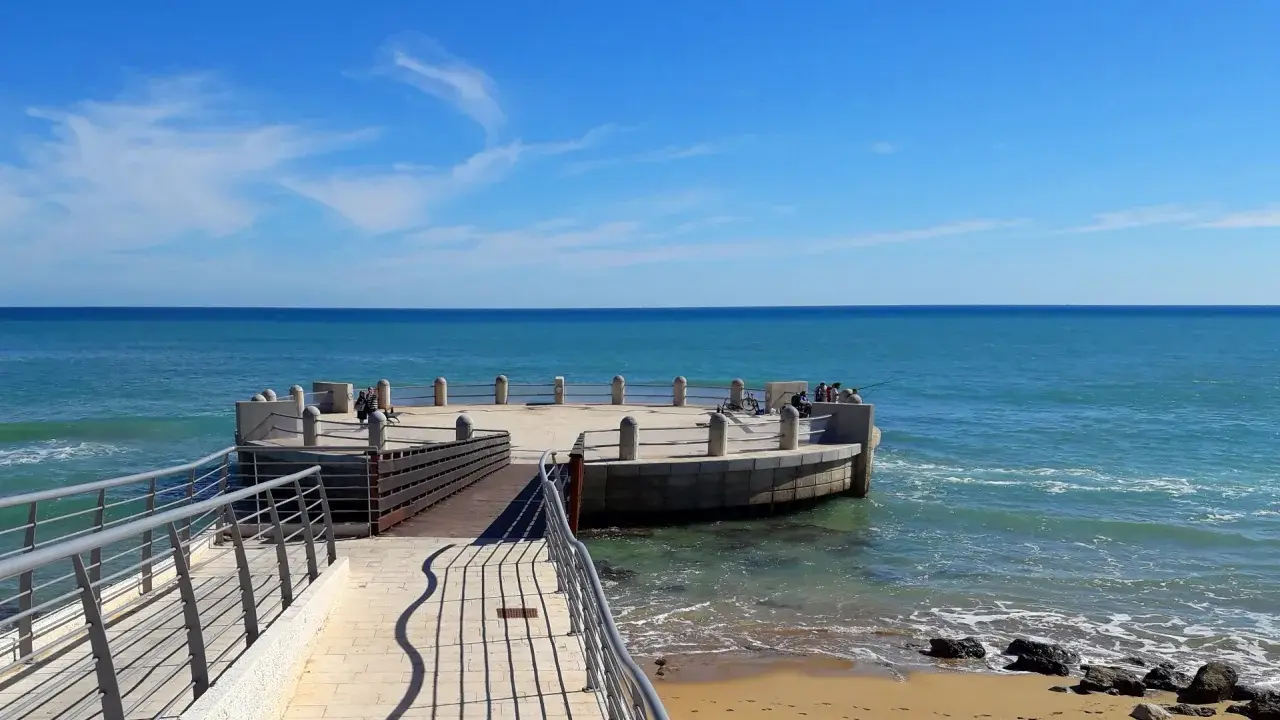La rotonda sul mare di Avola, con il suo molo in legno e la terrazza circolare, offre una vista mozzafiato sul blu intenso del Mediterraneo.