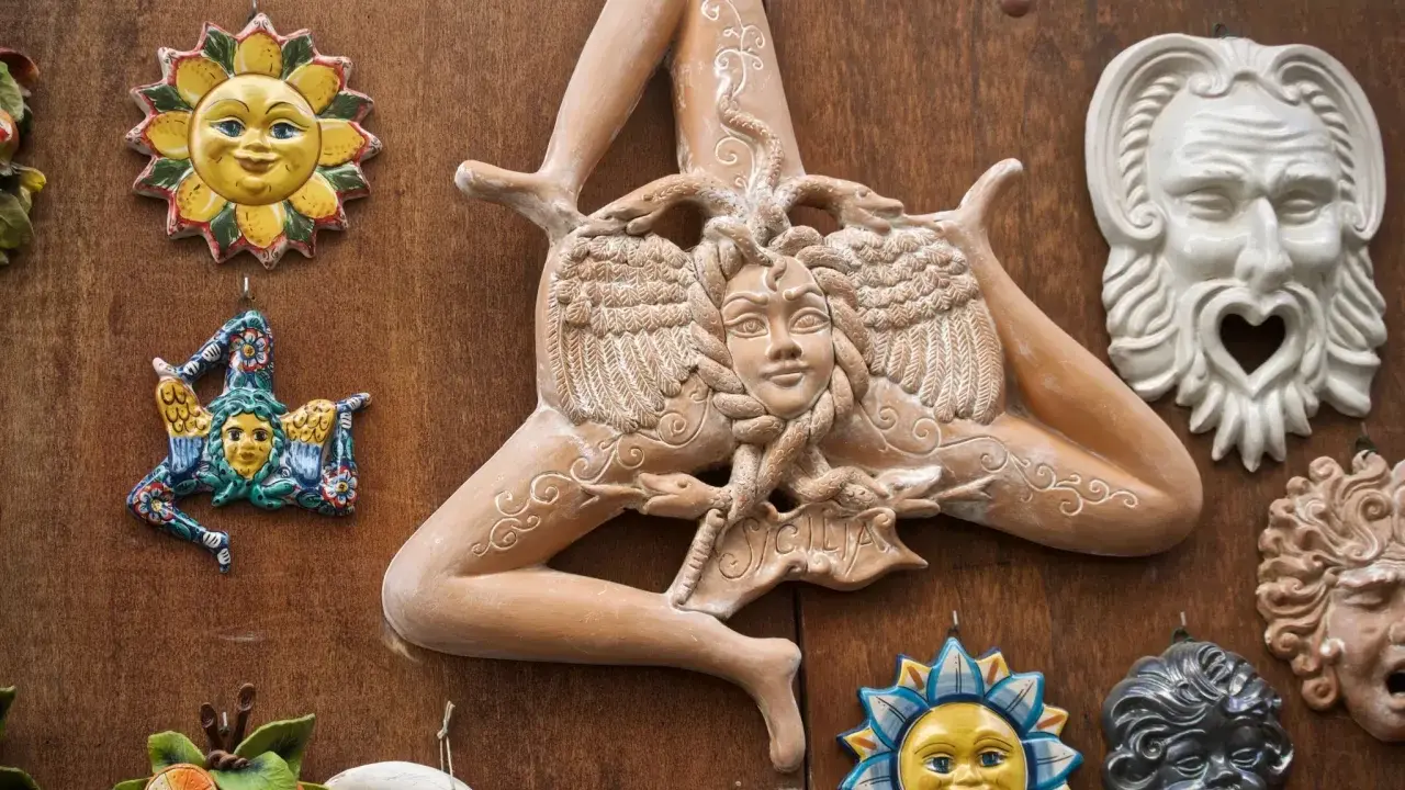 Ceramiche siciliane con la Trinacria, sole e maschere, simboli delle superstizioni siciliane.