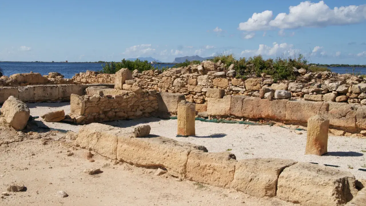 Rovine antiche a Mozia, cosa vedere: resti di mura e colonne di pietra con il mare sullo sfondo sotto un cielo azzurro.