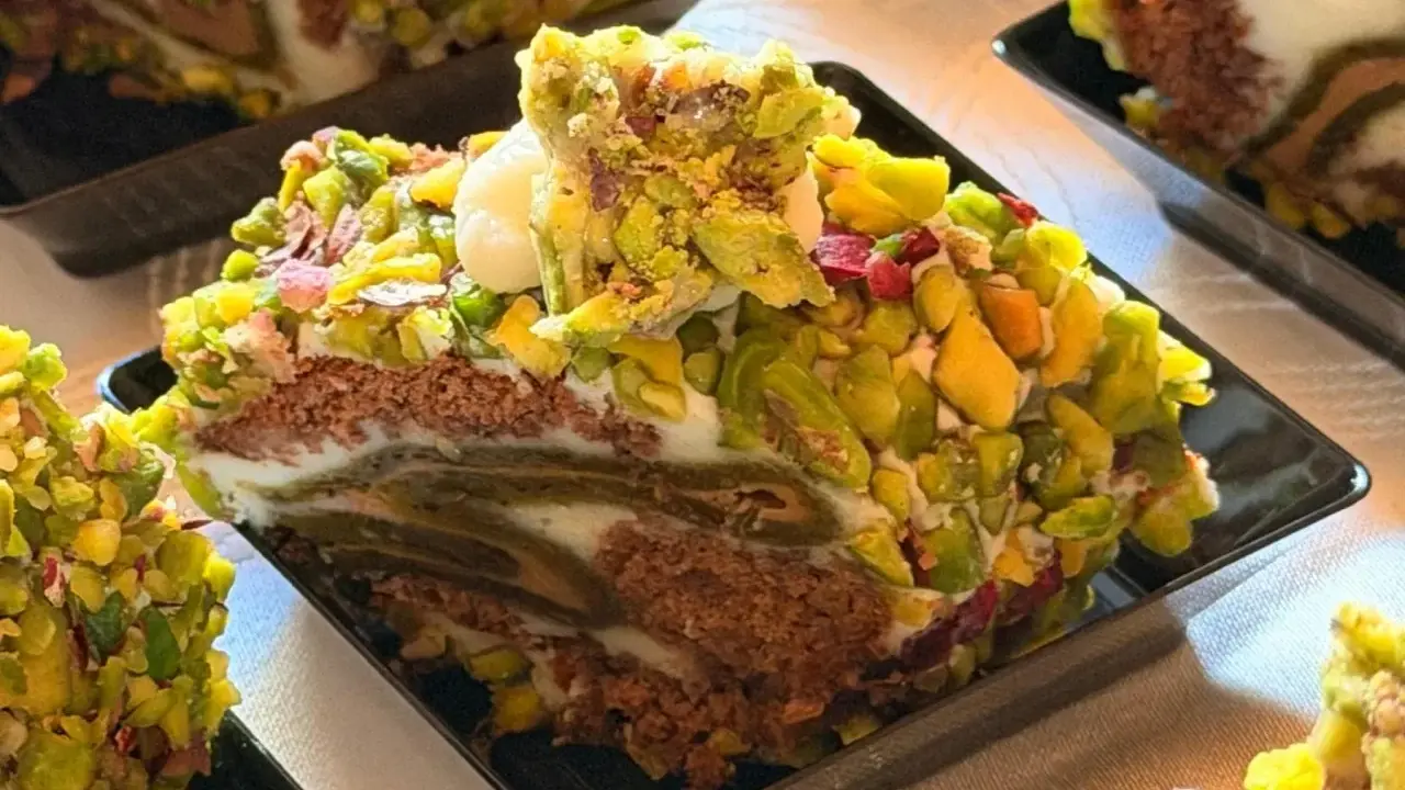 Fetta di rollò nisseno ricoperta di pistacchi e crema. Un dolce invitante e colorato.