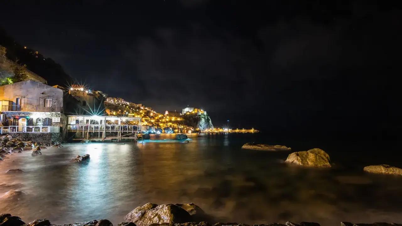 Scilla di notte: luci, castello e mare calmo. Perfetto per scoprire cosa fare a Scilla la sera, tra ristoranti sul mare e borghi illuminati.