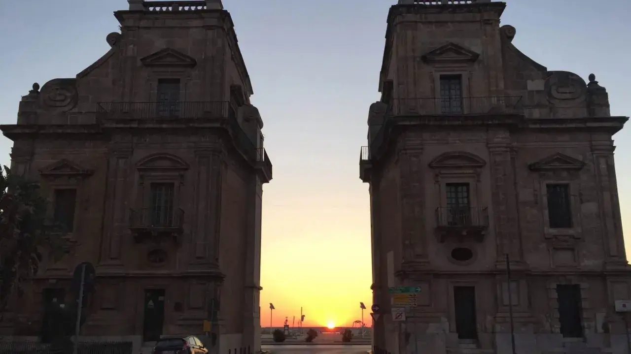 Tramonto tra i due palazzi che incorniciano la porta del sole a Palermo.
