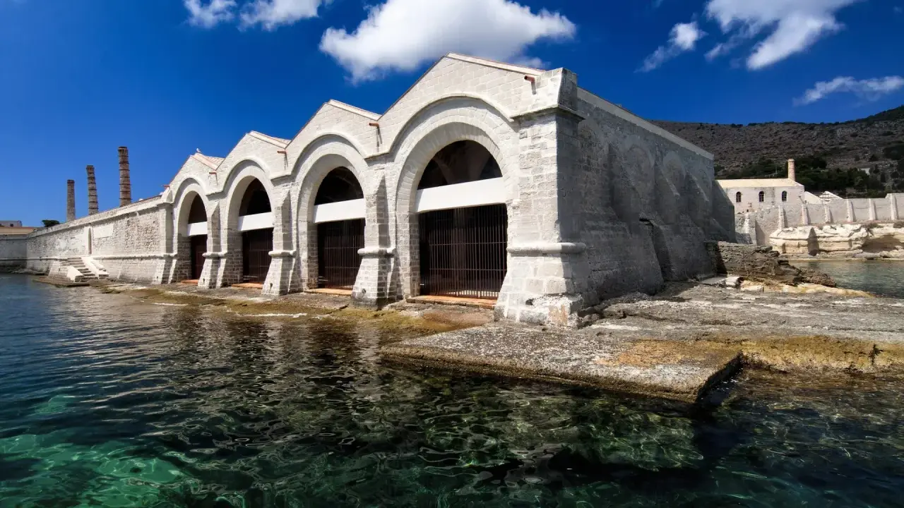 Antica tonnara, un tempo fiorente grazie a Ignazio Florio Senior, con archi imponenti sul mare cristallino.