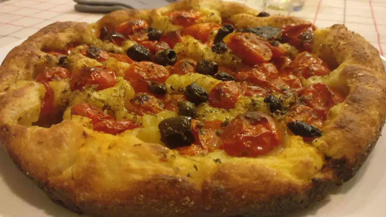 Focaccia con pomodorini e olive, un tripudio di specialità pugliesi salate. Croccante fuori, morbida dentro, profumata di erbe aromatiche.