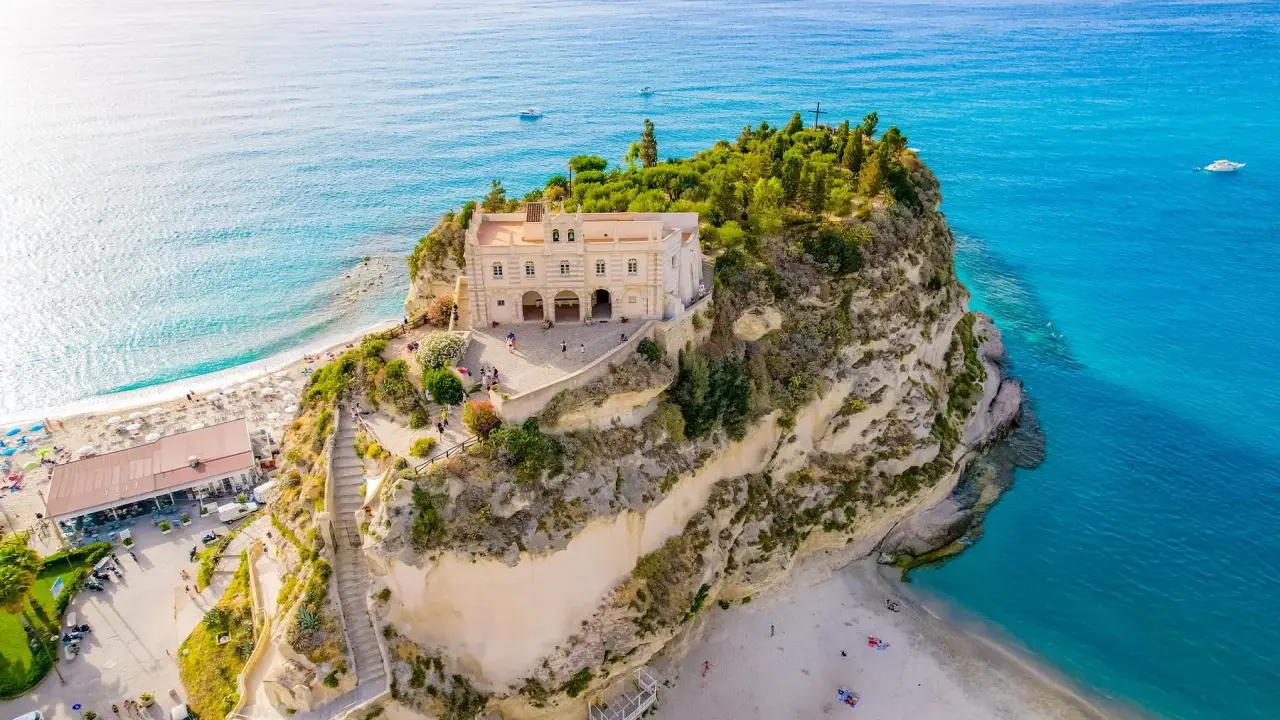 Santuario di Santa Maria dell'Isola a picco sul mare turchese, un must per chi cerca cosa fare a Tropea. Spiaggia e panorama mozzafiato.