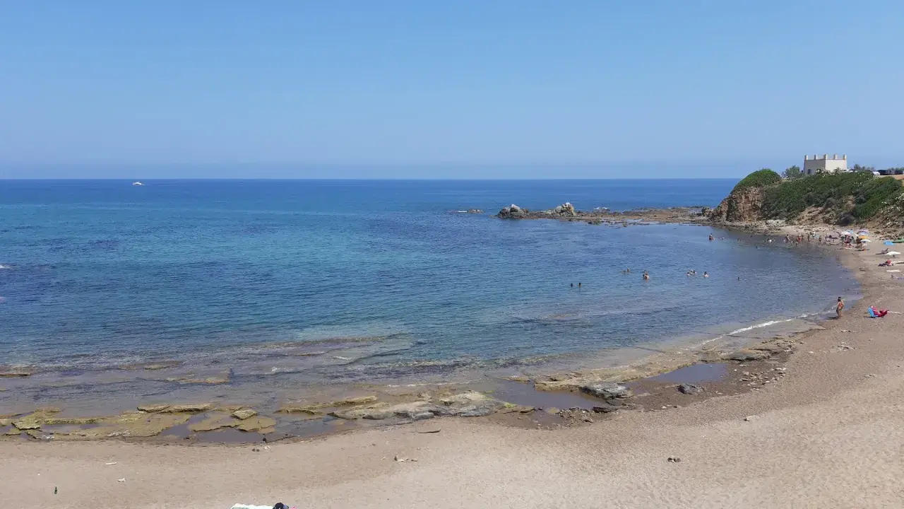 La **spiaggia dei Settefrati** offre acque cristalline e una baia tranquilla, con bagnanti che si godono il sole e il mare.