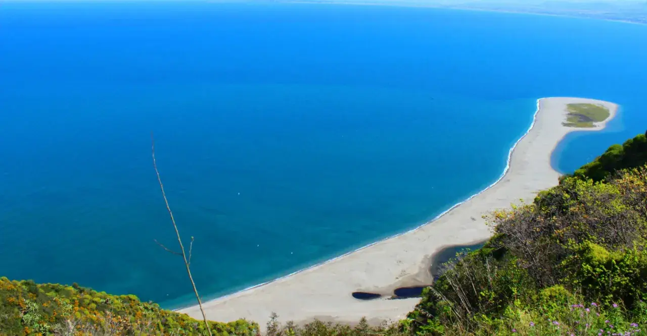 La **marinello spiaggia** si estende in un arco di sabbia chiara, lambita da un mare azzurro intenso. Laghi interni e vegetazione rigogliosa incorniciano questo angolo di paradiso.