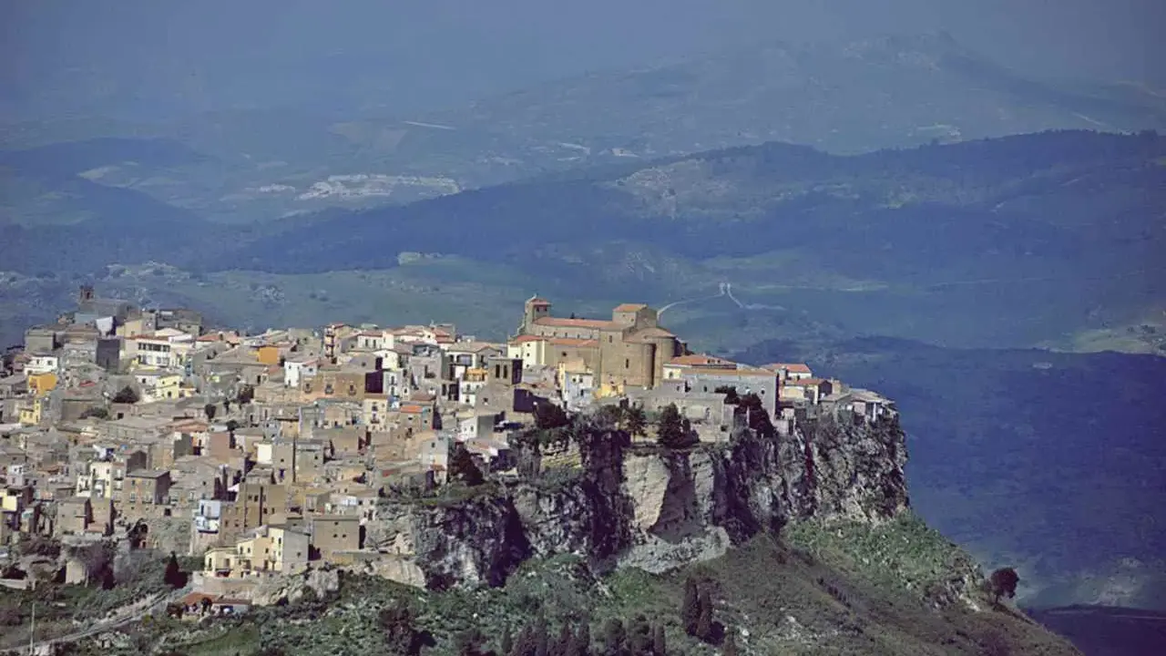 Borgo arroccato su una rupe, la città più alta della Sicilia domina un paesaggio collinare.