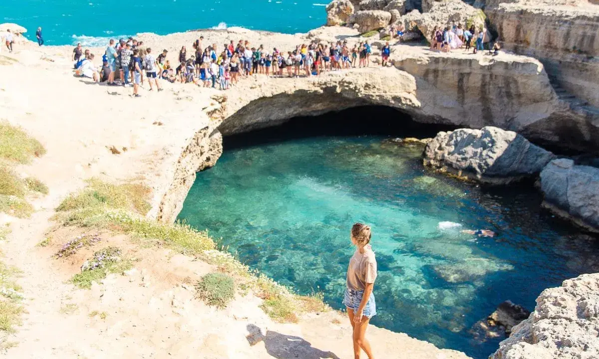 La Grotta della Poesia, con il suo mare cristallino, attira molti visitatori, ma il divieto di balneazione è ben visibile.