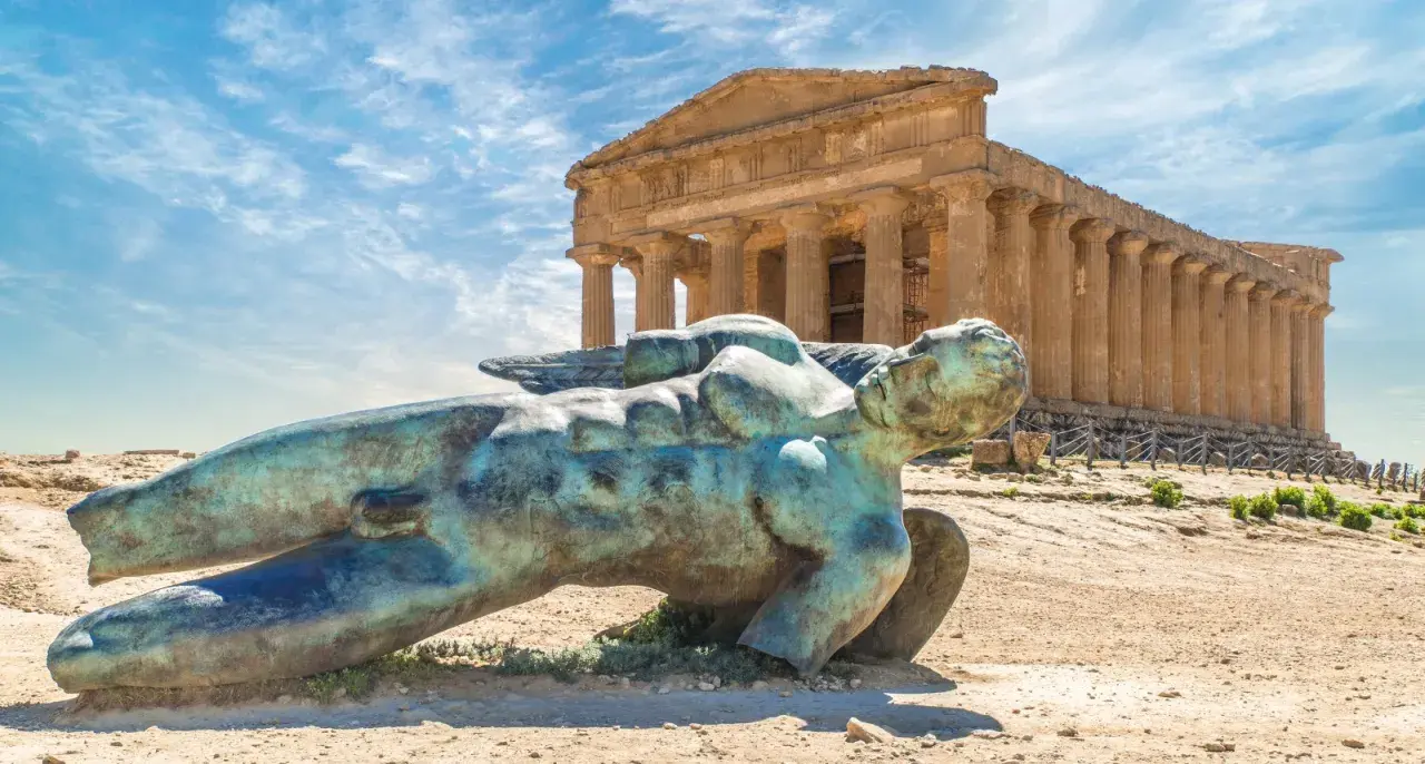Statua di Icaro caduto nella Valle dei Templi, Agrigento. Il tempio dorico sullo sfondo è il Tempio della Concordia.