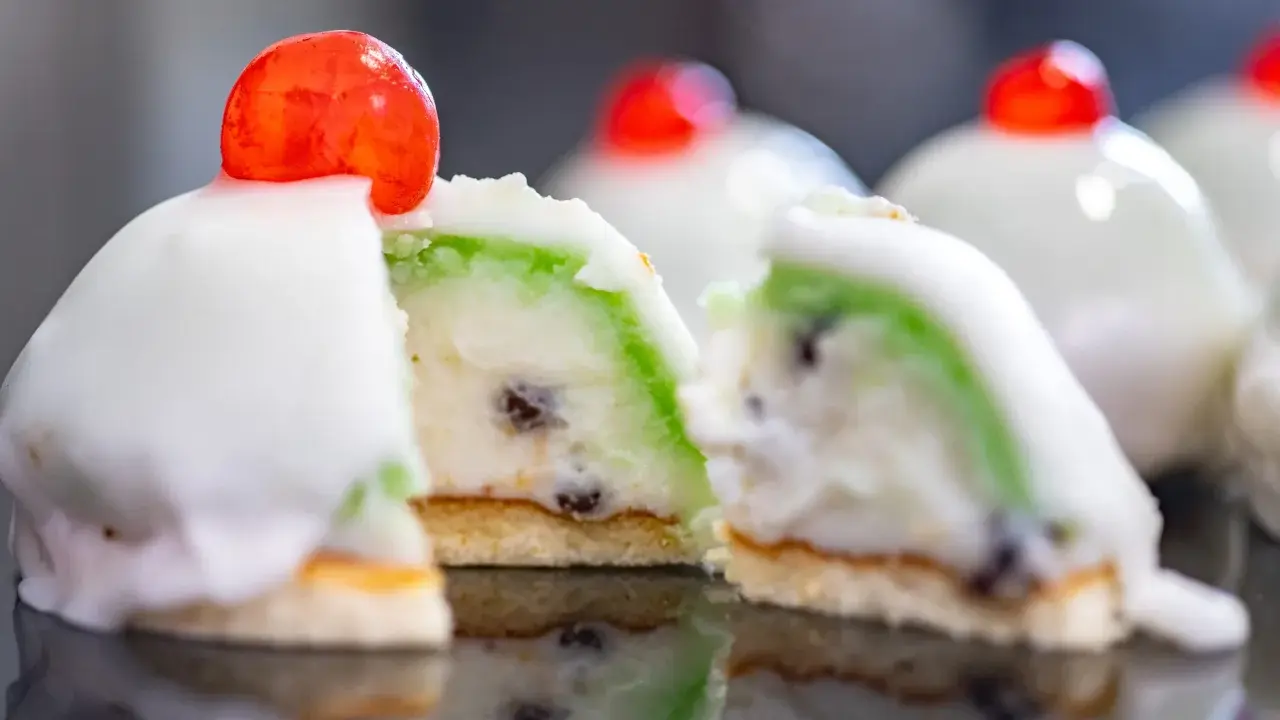 Dolci siciliani con glassa bianca, ripieno verde e canditi, un assaggio dei piatti tipici siciliani.