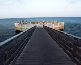 Passeggiata sul lungomare di Avola di sera, con persone che si godono la vista dal molo circolare.