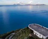 La guardiola Piraino domina il mare blu cobalto. All'orizzonte, le isole Eolie emergono dalla foschia.