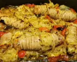 Stigghiole palermitane, un piatto saporito con interiora di agnello arrotolate e cotte al forno con cipolle e pomodorini.