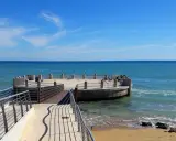 La rotonda sul mare di Avola, con il suo molo in legno e la terrazza circolare, offre una vista mozzafiato sul blu intenso del Mediterraneo.
