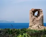 Torre saracena in rovina, un luogo suggestivo da scoprire a Terrasini, con il mare blu e le montagne sullo sfondo.