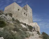 Antica fortezza, la Madonna del Castello di Palma di Montechiaro, si erge su un colle roccioso sotto un cielo azzurro.