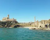 Antica tonnara di Portopalo con il castello sulla scogliera e le rovine di un'antica struttura industriale.