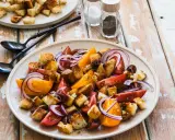 Un piatto di panzanella siciliana con pomodori, cipolla rossa e crostini croccanti.