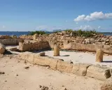 Rovine antiche a Mozia, cosa vedere: resti di mura e colonne di pietra con il mare sullo sfondo sotto un cielo azzurro.