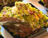 Fetta di rollò nisseno ricoperta di pistacchi e crema. Un dolce invitante e colorato.