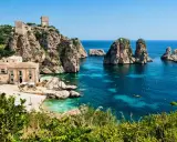 Baia con faraglioni e torri antiche, ideale per scoprire come arrivare a Scopello e godersi il mare cristallino.