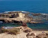 Scogliera rocciosa con acqua cristallina, dove si narra avvenne lo sbarco dei turchi. Due persone sedute ammirano il panorama.