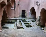 Antico lavatoio a Cefalù, con vasche in pietra e archi in rosa antico.