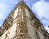Angolo del palazzo Beneventano a Scicli, con balconi in ferro battuto e sculture barocche.