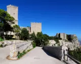 Erice: cosa vedere? Un antico castello domina il paesaggio, con torri imponenti e mura merlate che si stagliano contro il cielo azzurro.