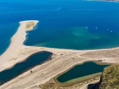 La Madonna di Tindari veglia sulla spiaggia, con le sue acque turchesi e la sabbia dorata che si estendono verso il mare.