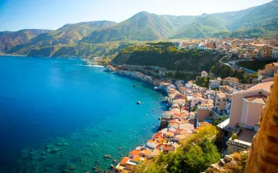 Scogliera con case colorate affacciata sul mare cristallino, un vero gioiello tra le più belle spiagge della Calabria.