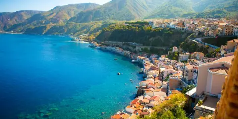 Scogliera con case colorate affacciata sul mare cristallino, un vero gioiello tra le più belle spiagge della Calabria.