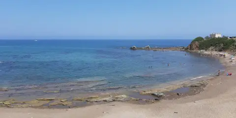 La **spiaggia dei Settefrati** offre acque cristalline e una baia tranquilla, con bagnanti che si godono il sole e il mare.