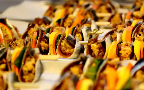 Deliziosi antipasti siciliani su spiedini, con pesce, agrumi e verdure colorate, pronti per essere gustati.