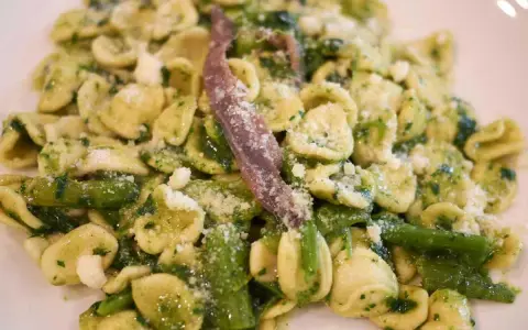 Orecchiette con cime di rapa, uno dei piatti tipici pugliesi primi, condite con acciughe e formaggio grattugiato.