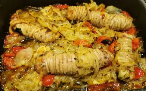 Stigghiole palermitane, un piatto saporito con interiora di agnello arrotolate e cotte al forno con cipolle e pomodorini.
