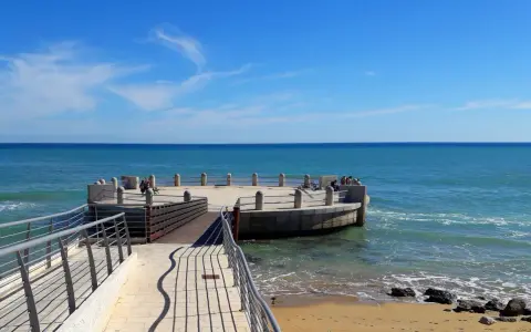 La rotonda sul mare di Avola, con il suo molo in legno e la terrazza circolare, offre una vista mozzafiato sul blu intenso del Mediterraneo.