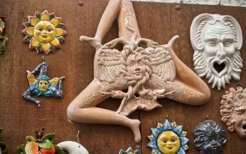 Ceramiche siciliane con la Trinacria, sole e maschere, simboli delle superstizioni siciliane.