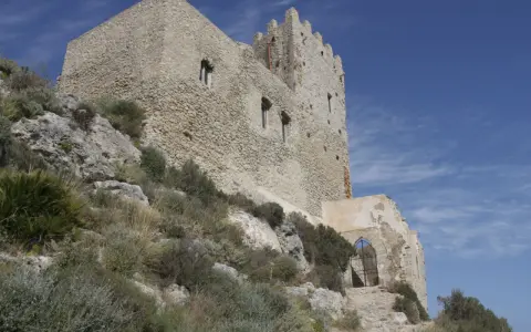 Antica fortezza, la Madonna del Castello di Palma di Montechiaro, si erge su un colle roccioso sotto un cielo azzurro.