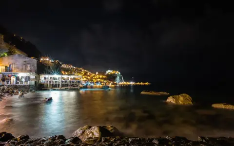 Scilla di notte: luci, castello e mare calmo. Perfetto per scoprire cosa fare a Scilla la sera, tra ristoranti sul mare e borghi illuminati.