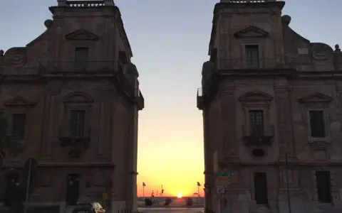 Tramonto tra i due palazzi che incorniciano la porta del sole a Palermo.