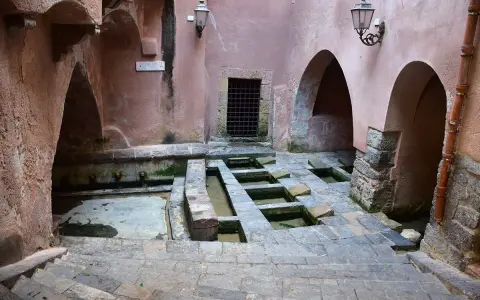 Antico lavatoio a Cefalù, con vasche in pietra e archi in rosa antico.