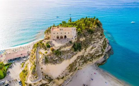 Santuario di Santa Maria dell'Isola a picco sul mare turchese, un must per chi cerca cosa fare a Tropea. Spiaggia e panorama mozzafiato.