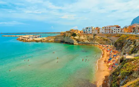 La spiaggia di Terrasini, con la sua scalinata che scende verso il mare cristallino, è un luogo incantevole per godersi il sole e fare il bagno.