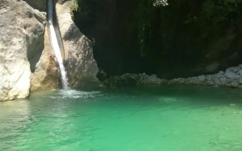 Cascata che si getta nella **pozza della Madonna**, un'oasi di acqua cristallina tra rocce e vegetazione rigogliosa.